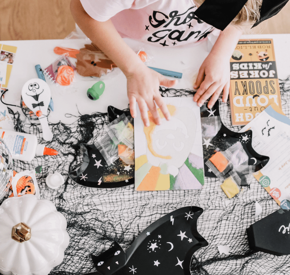 Inside a fall craft box with Halloween-themed activities and supplies
