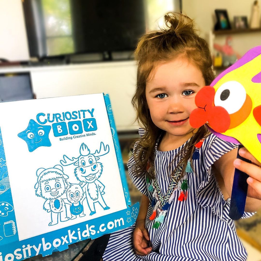 Child reading activity book from craft box