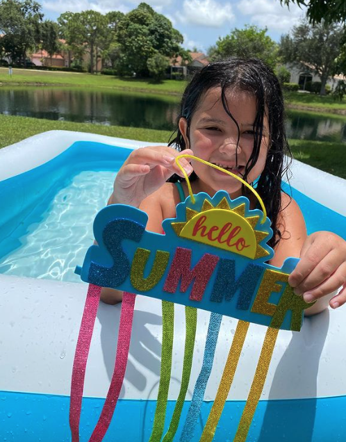 Child showing off summer craft creation